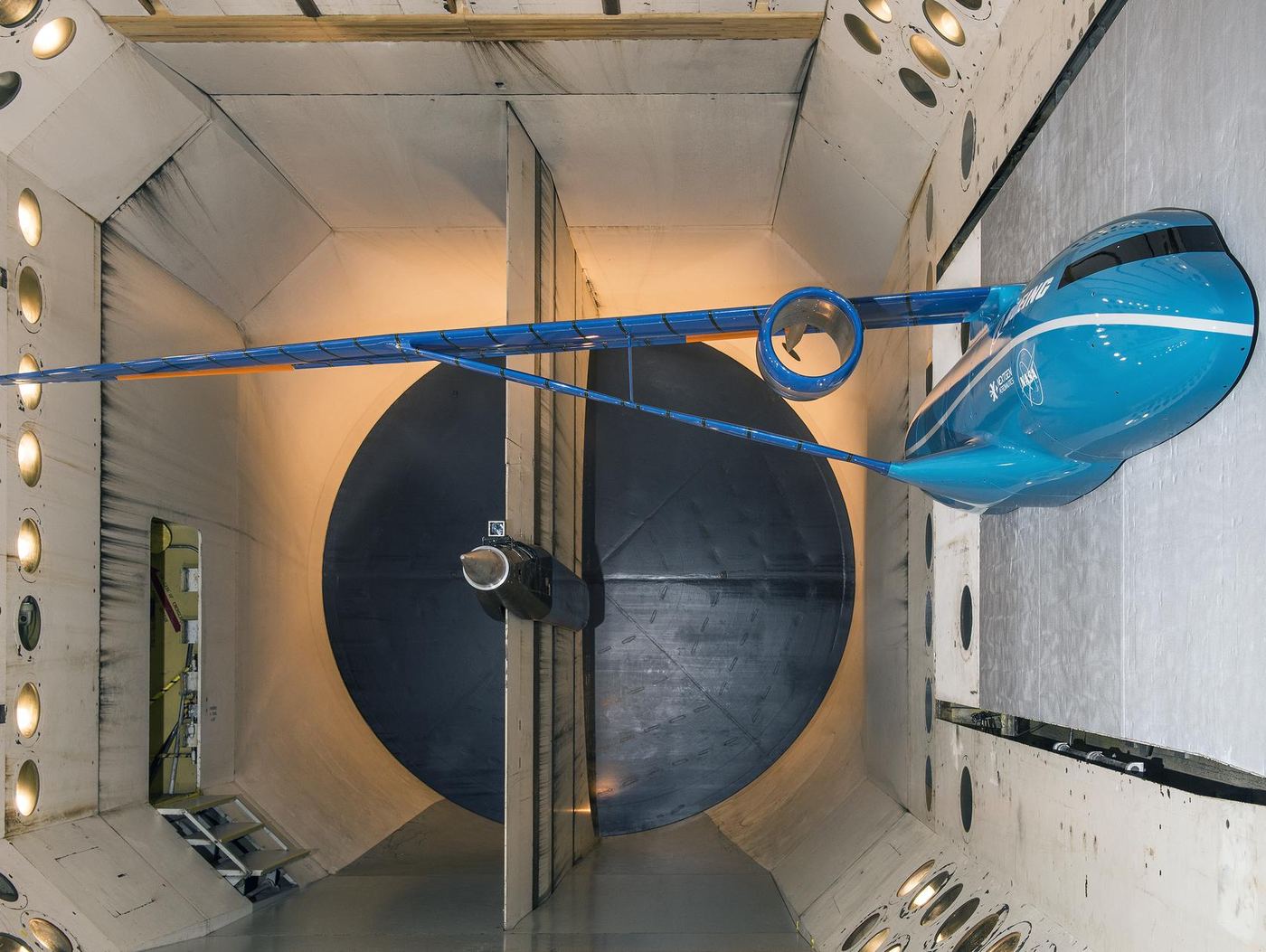 A truss-braced aircraft wing model mounted inside a wind tunnel test section.